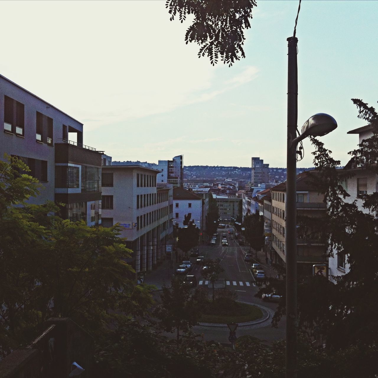 building exterior, built structure, architecture, tree, low angle view, sky, city, clear sky, residential building, residential structure, building, branch, sunlight, day, outdoors, street light, house, railing, growth, no people