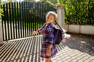 Back to school. girl with backpack runs to school from home at the first day after vacation
