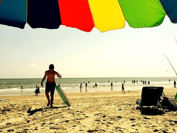 People at beach against sky