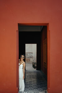 Woman wearing sunglasses standing by doorway