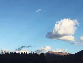 Scenic view of mountains against blue sky