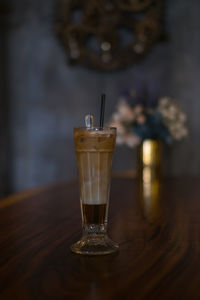 Close-up photo of glass cup with ice latte on the table in a coffee shop. glass with iced cappuccino