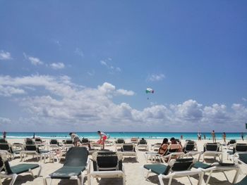 Panoramic view of people at beach against sky