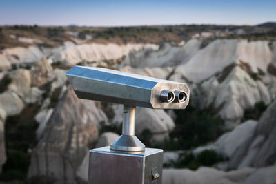 Close-up of coin-operated binoculars on rock