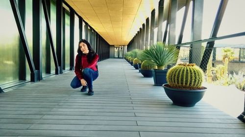 Full length of woman standing on potted plant