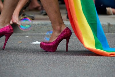 Low section of person wearing multi colored shoes