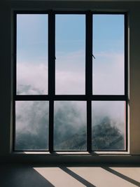 Sky seen through glass window of building