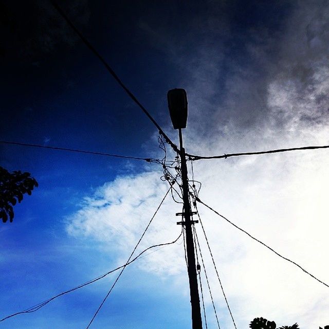 low angle view, power line, electricity, power supply, cable, sky, electricity pylon, connection, technology, fuel and power generation, power cable, cloud - sky, lighting equipment, street light, silhouette, cloud, pole, cloudy, outdoors, no people