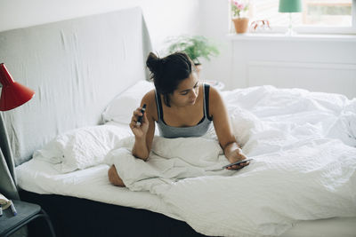 Young woman lying on bed at home