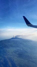 Airplane flying over sea against blue sky