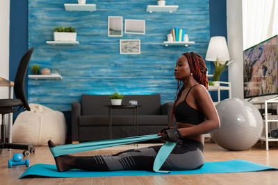 Side view of woman sitting on floor