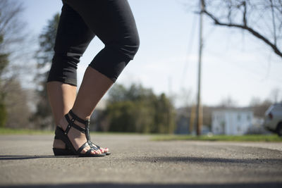 Low section of woman standing on road