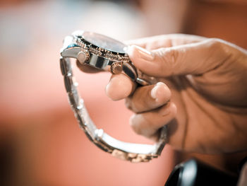 Cropped hand holding wristwatch