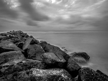 Rocks by sea against sky