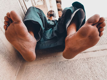 Low angle view of man sitting on retaining wall