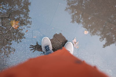 Low section of man standing on puddle