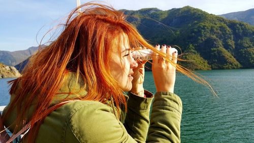 Close-up of woman looking through object