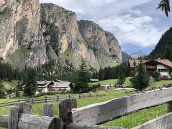 Houses by trees and mountains against sky