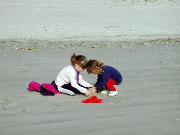 Sisters playing with sand at beach