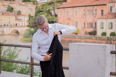 Businessman using mobile phone while standing outdoors