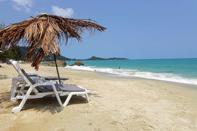 Chairs on beach against sky