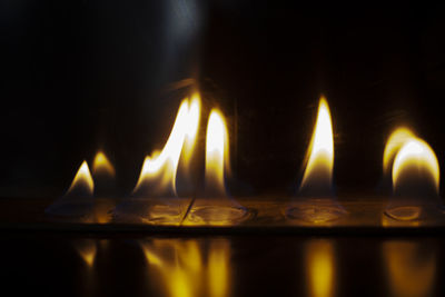 Close-up of lit candles in dark