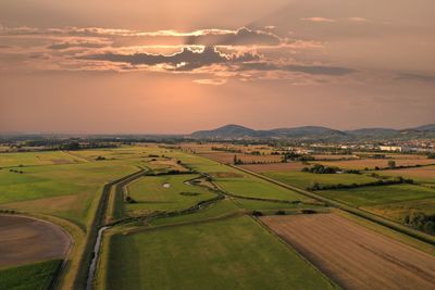 Scenic view of agricultural field against sky during sunset