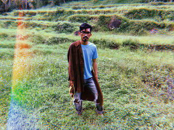 Portrait of smiling young man standing on grass