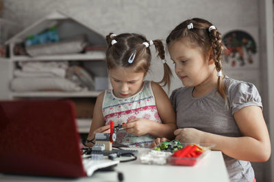 Portrait of siblings playing with toy blocks at home