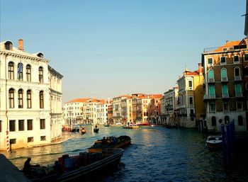 View of canal in city against clear sky