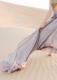 Low section of woman on sand in desert