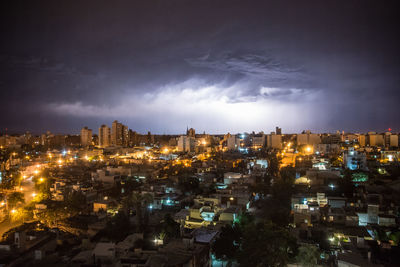 High angle view of illuminated city against sky at night