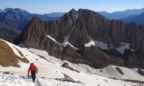 Rear view of man standing on snowcapped mountain