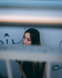 Young woman seen through window