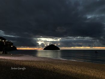 Scenic view of sea against dramatic sky during sunset