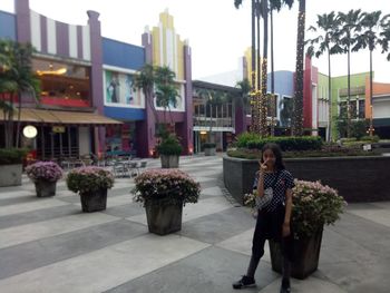 Portrait of woman with potted plants in city