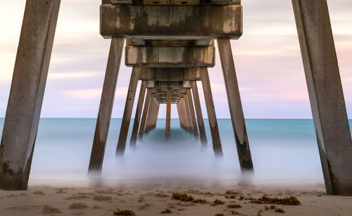 View of pier on beach against sky