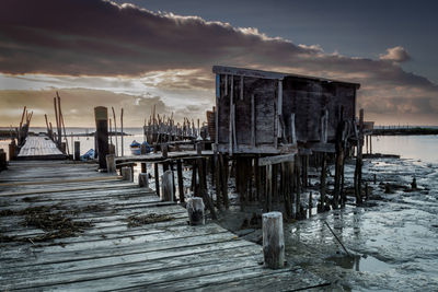 Wooden pier on sea against sky during sunset