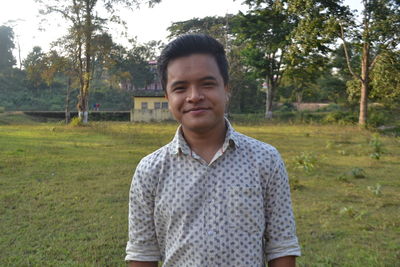 Portrait of young man standing on field