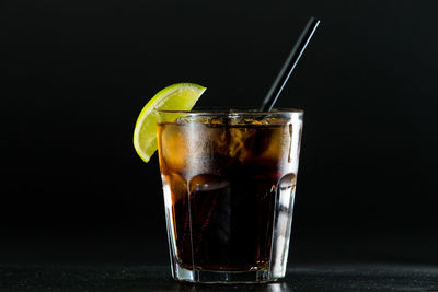 Close-up of beer glass against black background