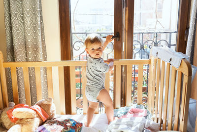 Boy playing on window at home