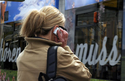 Portrait of woman using mobile phone in city