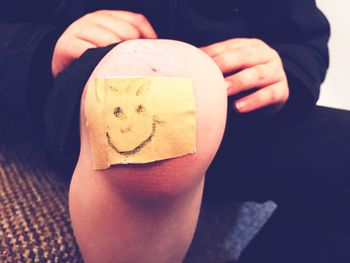 Cropped image of hand holding tattoo