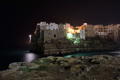 View of buildings over sea at night