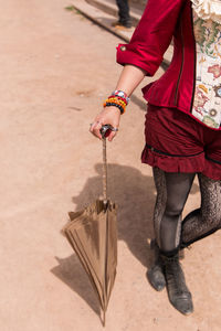 Low section of woman walking with umbrella on street