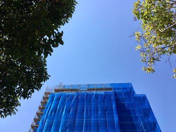 Low angle view of modern building against clear blue sky