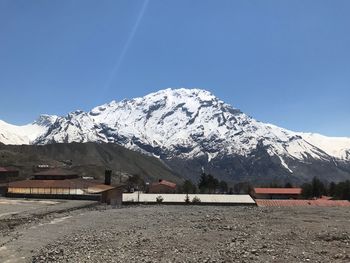 Scenic view of snowcapped mountains against clear blue sky