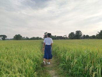 Rear view of woman walking on field