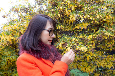 Portrait of young woman wearing autumn leaves