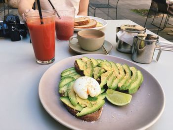 Poached egg on bread with avocado slices and juices